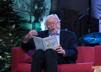 a person sitting on a red couch reading a book